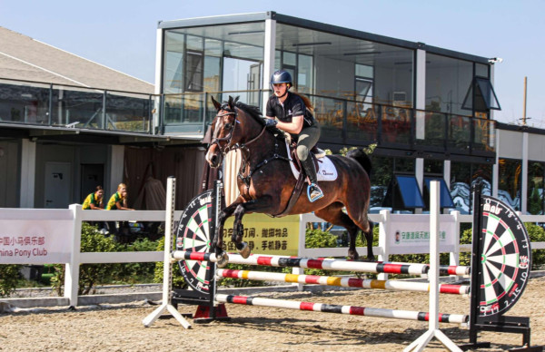 Mia riding in a practice round in China